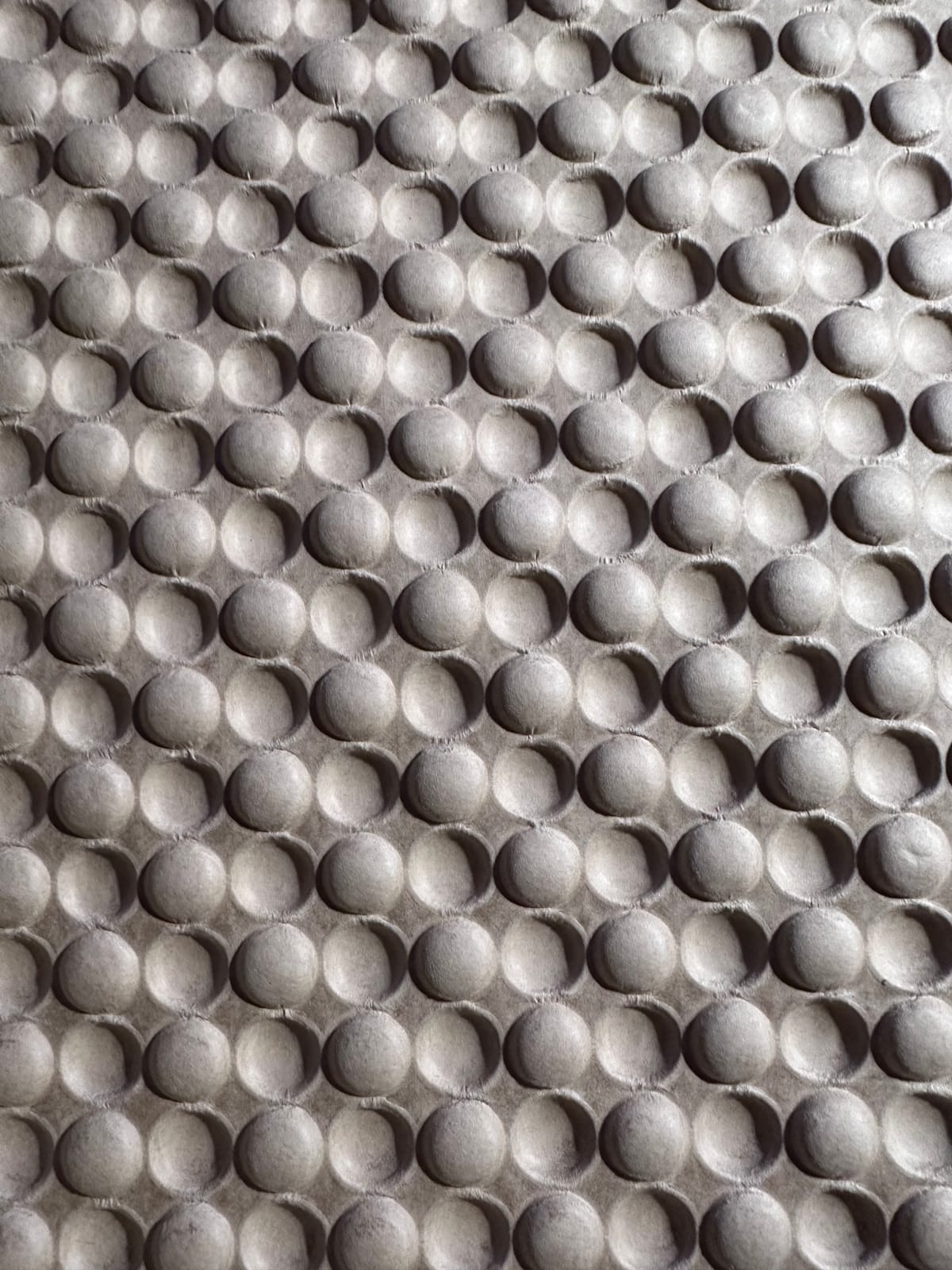 Dramatically lit embossed/debossed packing kraft paper that is almost like bubble wrap.