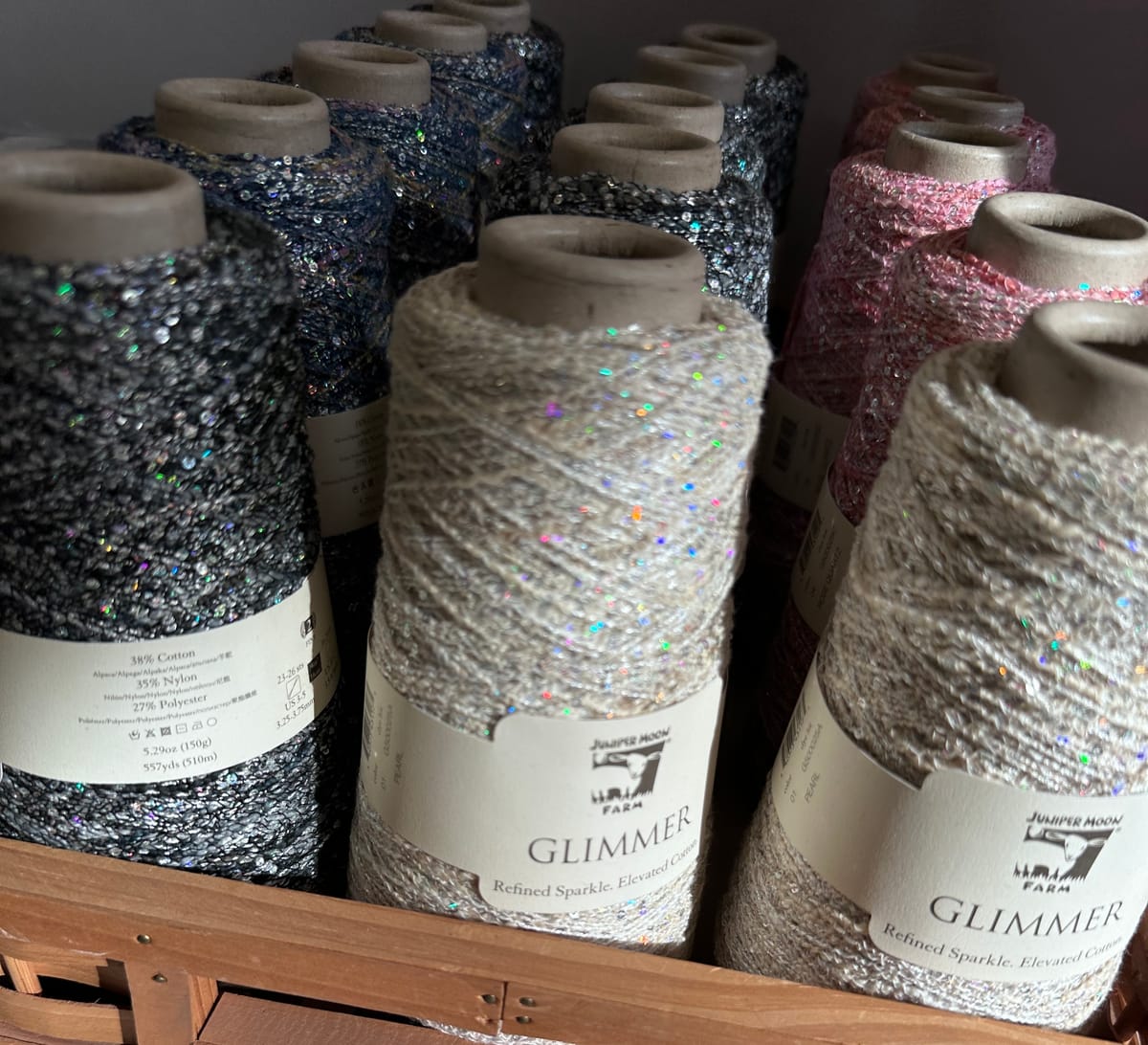 Rows of very sparkly spools of yarn/thread in the sun.